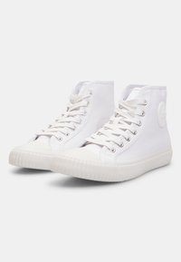Valged kõrge säärega sneakerid, mis on valmistatud kangast, kummist tallaga, metallist silmadega paelte jaoks ja tekstureeritud varbadetailiga.