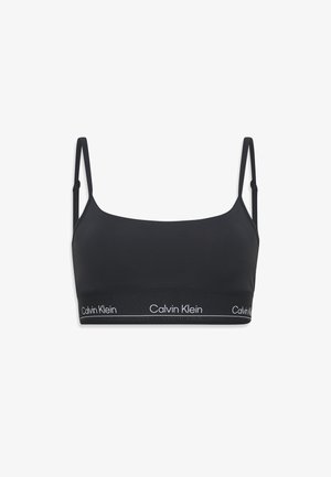 Zwarte bralette van gladde stof, met dunne verstelbare bandjes en een brede elastische band met het "Calvin Klein" logo.