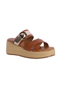 Sandalias de cuña de cuero marrón con una plataforma de yute trenzado, que presentan correas cruzadas y una hebilla dorada decorativa en una correa de color crema.