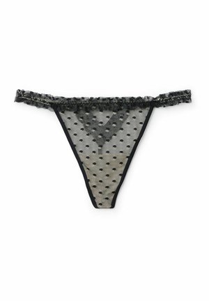 Black polka dot sheer lace thong with a ruffled trim along the waistband and thin side straps. Decorative pattern throughout the fabric.