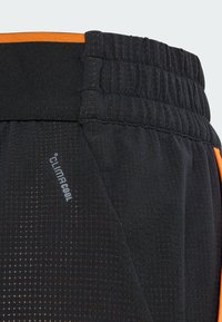 Black athletic shorts featuring a textured pattern, elastic waistband, and orange accents. Includes "climacool" branding.