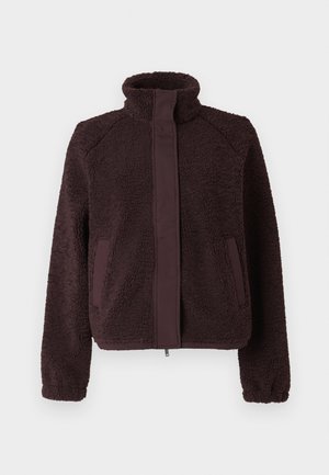 Brun fleecejakke med høj krave, lynlås foran og sidelommer. Har tekstureret yderside og glatte stofdetaljer.