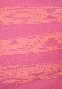 Jasnoróżowa tkanina z geometrycznym wzorem w nieco ciemniejszym odcieniu różu. Posiada paski z trójkątami oraz motywami zygzakowymi na powierzchni.
