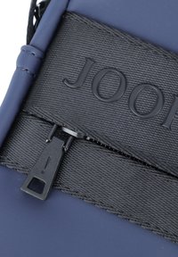 Busta blu navy con un pannello nero testurizzato, dotata di una cerniera nera e del logo in rilievo "JOOP!" sulla superficie.