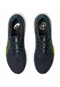 Marineblaue Sportschuhe mit einem atmungsaktiven Mesh-Obermaterial, strukturierten Mustern, neon-gelben Akzenten und einer gepolsterten weißen Sohle.