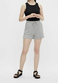 Débardeur noir côtelé, short en coton gris avec cordon de serrage, et sandales à plateforme noires avec des brides croisées. Design simple et décontracté.