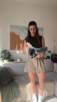 Μαύρο και γκρι προϊόν σε πλαστική συσκευασία κρατούμενο από ένα άτομο, με ομαλή υφή και ρυθμιζόμενα χαρακτηριστικά, τοποθετημένο σε μια άνετη σαλονά.