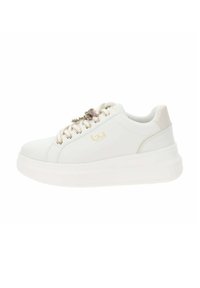 Zapatilla blanca con parte superior lisa, acentos dorados y una decoración de flor. Suela blanca gruesa para mayor altura y comodidad.
