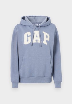 Svetlo modra jopa s kapuco in sprednjim žepom ter belim logotipom "GAP" na prsih, z vrvico za zategovanje na kapuci ter rebrastimi manšetami in spodnjim robom.