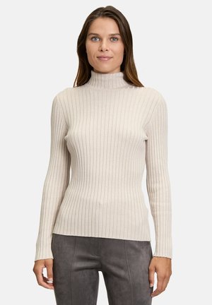 Cremfarbener, gerippter Rollkragenpullover mit langen Ärmeln und figurbetonter Passform, hergestellt aus einem weichen Strickmaterial mit subtiler Textur.