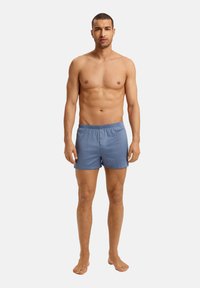 Blå bomullssimshorts med elastiskt midjeband och liten framficka, med en mjuk yta och avslappnad passform.