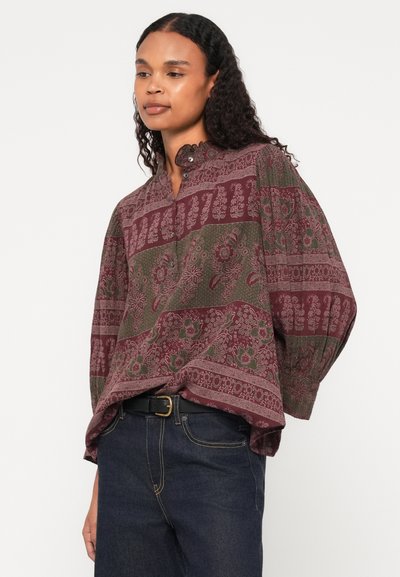 Garām piedurknēm blūze ar augstu kaklu, ar bordo un zaļu ziedu rakstu un horizontālām svītrām. Brīvi pieguloša ar pogu akcentiem.