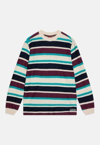 Stripet genser laget av teksturert stoff. Fargene inkluderer krem, marineblå, mørkerød og teal. Den har lange ermer og rund hals.