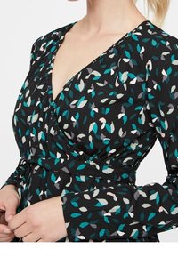 Abito a portafoglio floreale con sfondo nero e motivi di foglie in teal, rosa e grigio. Maniche lunghe e vita aderente con dettaglio a fiocco.