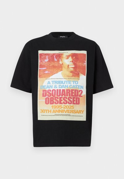 Tricou din bumbac negru cu un imprimeu grafic mare și colorat, având textul „UN TRIBUT PENTRU DEAN ŞI DAN CATEN” și „FANAT DSQUARED2.”