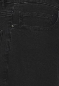 Svarta denimjeans med en klassisk femfickdesign, med en slät textur och subtila sömnadsdetaljer längs sömmarna.