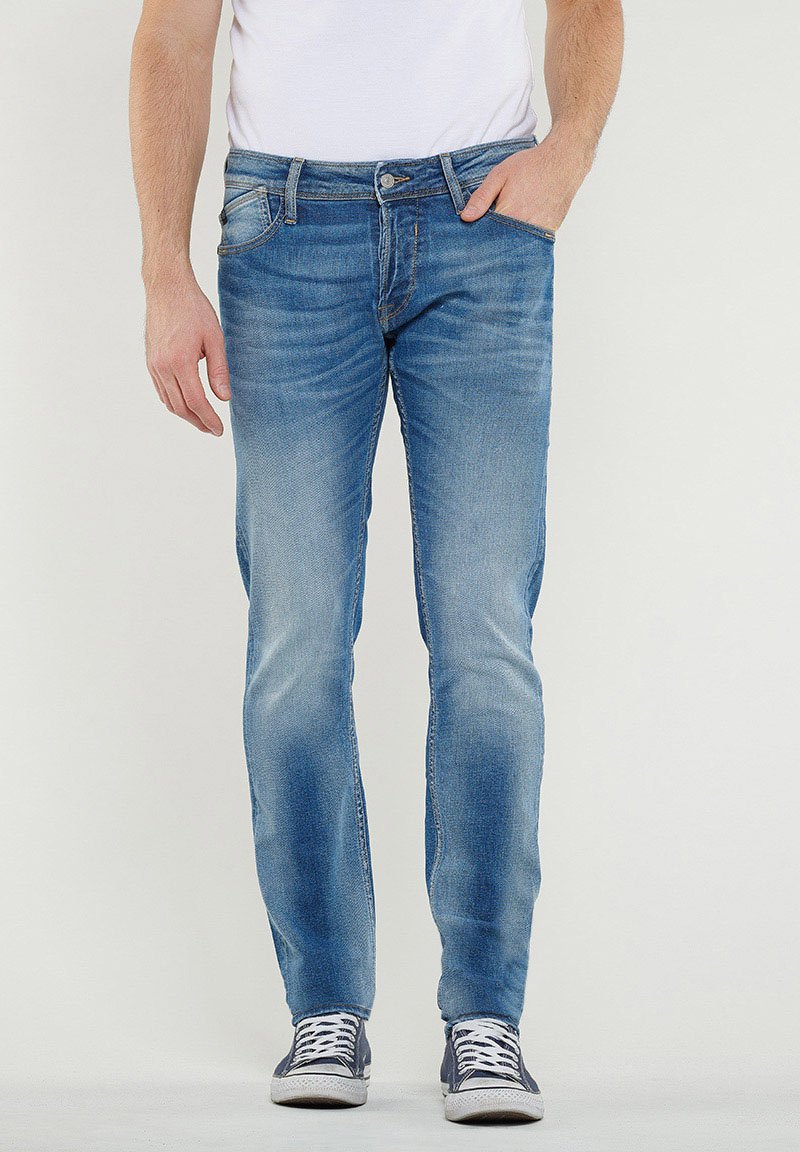 Lichtblauwe denim jeans met een slim fit, voorzien van voorzakken, een ritsluiting en subtiele vervaging. Draagt met donkere sneakers.