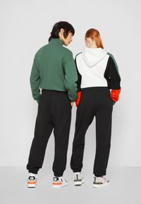 Lacoste EXCLUSIVE UNISEX - Tréningruha alsók - black
