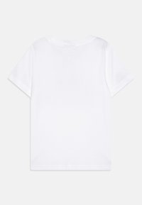T-shirt blanc à manches courtes avec un col rond. Tissu en coton lisse, sans motifs ni graphiques. Coupe droite avec un design simple.