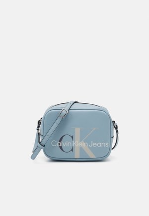 Sac bandoulière rectangulaire bleu clair avec sangle réglable et logo « Calvin Klein Jeans » à l’avant.