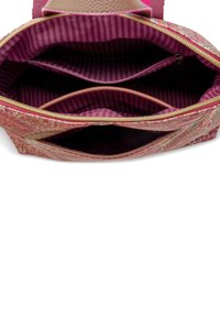 Interieur van een roze met een patroon handtas met twee ritscompartimenten en gestreepte voering. Gemaakt van stof met een zachte textuur en een gedetailleerd ontwerp.