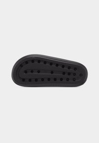 Μαύρη ελαστική σόλα παπουτσιού με στρογγυλεμένες άκρες και ανυψωμένα κυκλικά σχέδια πρόσφυσης τοποθετημένα σε συγκεντρικές σειρές.