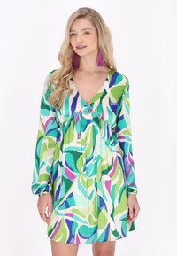 Rochie cu imprimeu floral, prezentând nuanțe vibrante de verde, albastru și violet. Mâneci lungi, decolteu în V și design cu talie empire. Material ușor.