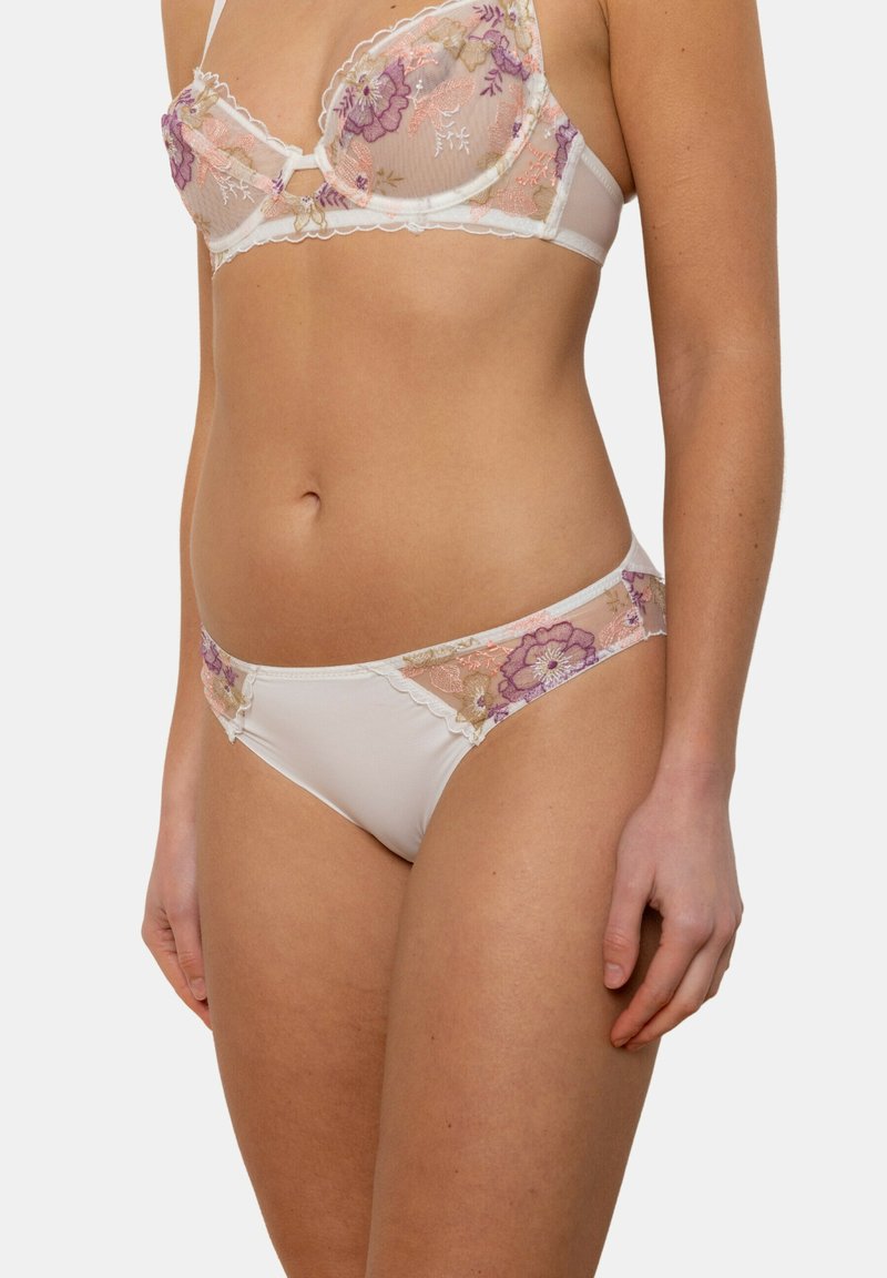 Soutien-gorge en dentelle blanche et culotte assortie mettant en valeur une broderie florale complexe dans des teintes de violet et de rose, des panneaux en maille transparente et des bords festonnés.