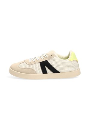 Zapatilla de malla beige y blanca con detalle lateral negro, cordones blancos y acento amarillo en el talón, mostrada de lado sobre un fondo blanco.