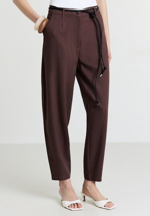 Braune maßgeschneiderte Hose in lockerer Passform, mit seitlichen Taschen, einem schwarzen Kordelzug und subtiler Textur. Klassischer Stil mit einem modernen Akzent.