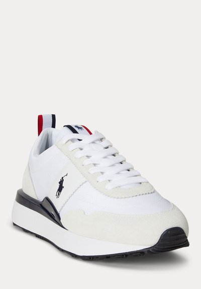 Pantof sport alb cu șireturi albe, vârf din piele întoarsă, margine neagră a tălpii și etichetă de prindere roșie, albă și albastră, cu logo negru cu jucător de polo pe lateral.