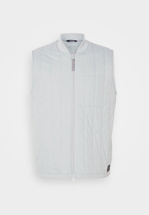 Gilet sans manches gris clair avec une texture matelassée, fermeture éclair sur le devant et une petite poche sur la poitrine. Il présente un col montant et un tissu imperméable.