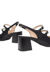 Scarpe slingback nere con punta arrotondata, tacco quadrato, doppie fibbie decorative e dettagli laterali a taglio. Texture liscia con design minimal.