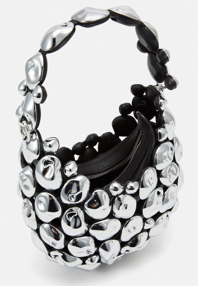 Black handbag featuring a sculptural design with shiny silver pebble-like accents. It has a textured surface and a zippered compartment.
