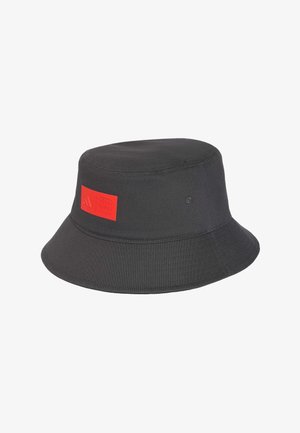 Zwarte bucket hat met een rode vierkante patch met het Adidas-logo en de tekst Audi Revolt aan de voorkant.