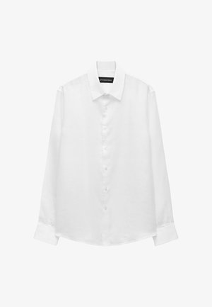 Chemise blanche à manches longues avec col pointu et poignets, présentée sur un fond blanc uni.