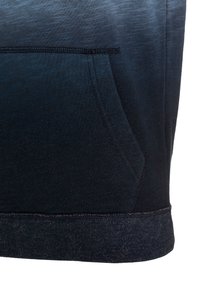 Tmavě modrá mikina s kapucí s texturovaným přechodem barev, přední kapsou a žebrovaným lemem. Měkká látka s hladkým povrchem a jemnými švy.