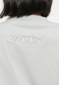 Ανοιχτό γκρι φούτερ με υφασμάτινο, κεντημένο λογότυπο "2NDDAY" στην πλάτη. Μαλακό ύφασμα με απλό, καθαρό σχεδιασμό και στρογγυλή λαιμόκοψη.