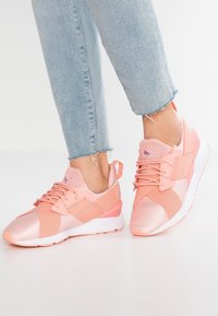 Zapatillas deportivas rosas con una combinación de material liso y texturizado, que cuentan con una parte superior de malla, cierre de cordones y suela de goma contrastante.