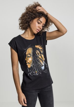 Black t-shirt with a graphic design featuring a profile of a person and a lion, detailed with colors of orange and yellow, set against a solid background.