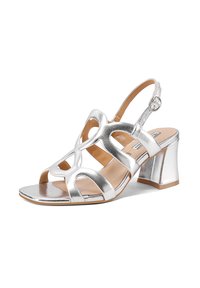 Sandali argentati metallizzati con tacco alto e aperti, dotati di cinturini sagomati e una cinghia alla caviglia regolabile. Tacco a blocco per stabilità.