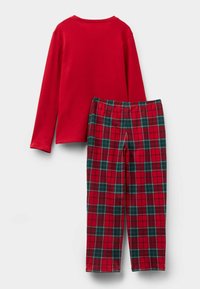 Czerwona koszula z długim rękawem w połączeniu z spodniami w kratę w odcieniach czerwieni, zieleni i czerni. Materiał z mieszanki bawełny z elastycznym pasem.