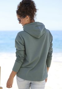 Felpa con cappuccio di colore verde tenue, tessuto morbido, vestibilità comoda, maniche lunghe e tasca a forma di kangaroo nella parte anteriore.