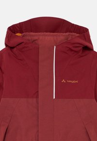 Red waterproof jacket featuring a hood, vertical front zipper, and a logo. The fabric has a smooth texture with contrasting panel design.