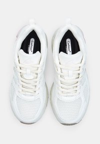 White athletic shoes featuring mesh and synthetic materials, textured detailing, flat laces, and pink accents on the heel.