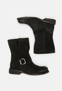 Black suede ankle boots featuring a patterned shaft, side buckle detail, elastic panel, and a low stacked heel.