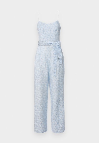 Gaiši zils kombinezons ar spageti siksnām, ziedu rakstu un saderīgu jostu ap vidu. Brīvs, plats kāju dizains.