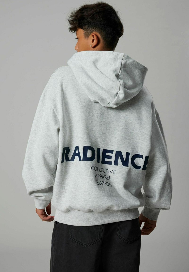 Felpa grigia con una grande stampa blu navy con la scritta "RADIENCE" sul retro, presenta un cappuccio con cordino e polsini e orlo a costine.