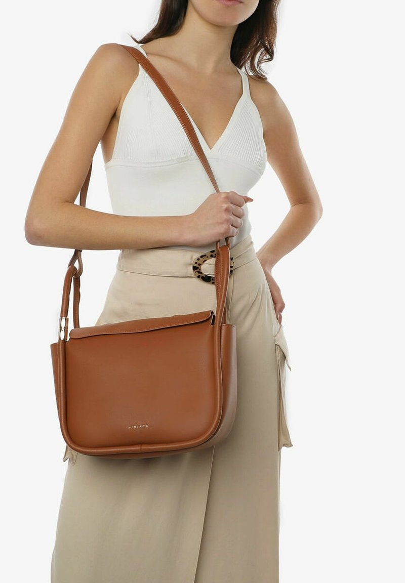 Brązowa skórzana torebka o wyrafinowanej konstrukcji, z regulowanym paskiem i zamkiem błyskawicznym na górze. Gładka tekstura z subtelnym detalem logo z przodu.