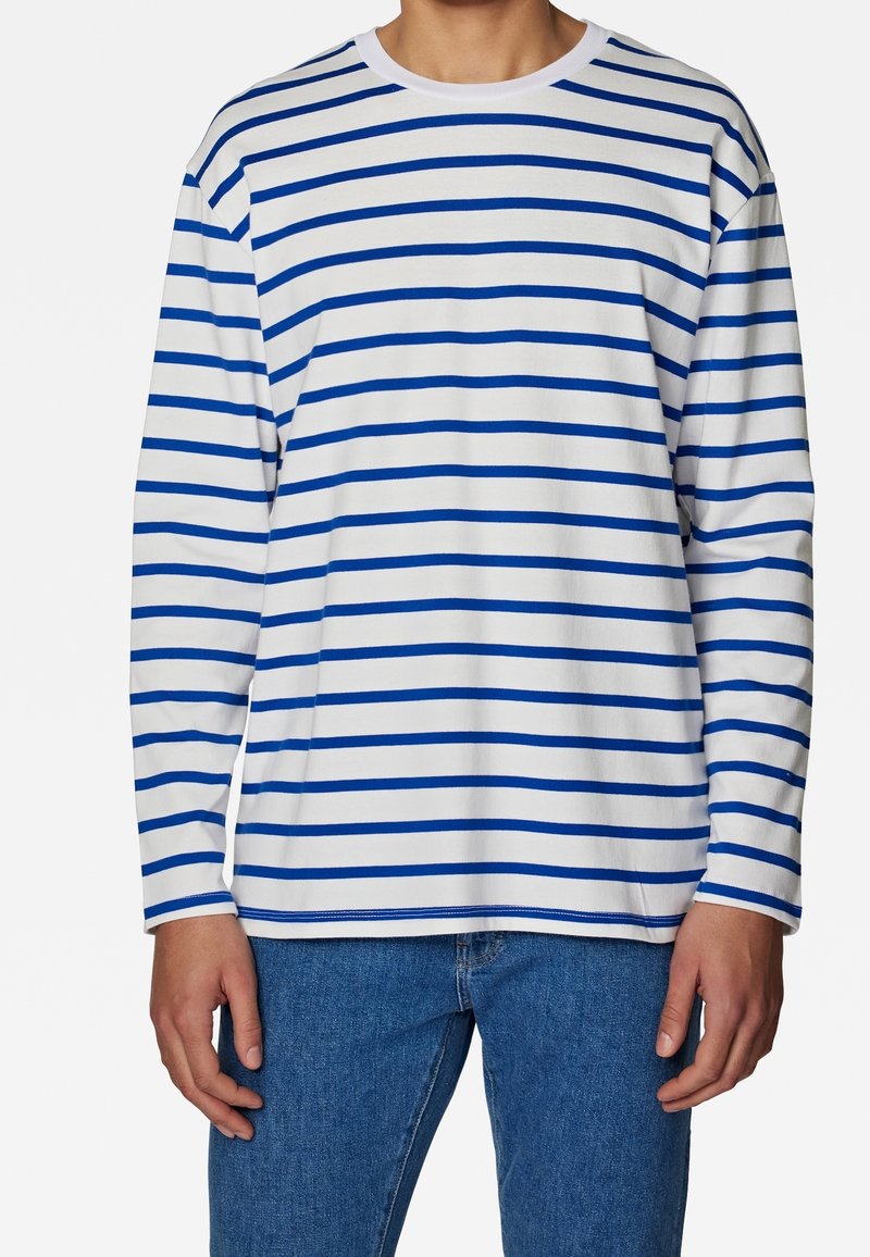 Långärmad randig skjorta i vitt med blå horisontella linjer, rund halsringning, mjukt tyg, avslappnad passform, parat med blå jeans.